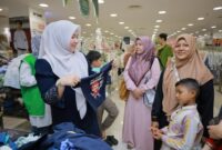 Bunda PAUD Aceh Besar Hj Rita Mayasari, membantu para anak yatim memilih baju lebaran, di pusat perbelanjaan di Kota Banda Aceh, Selasa (17/2/2026). FOTO/ MC ACEH BESAR