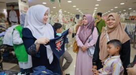 Bunda PAUD Aceh Besar Hj Rita Mayasari, membantu para anak yatim memilih baju lebaran, di pusat perbelanjaan di Kota Banda Aceh, Selasa (17/2/2026). FOTO/ MC ACEH BESAR