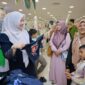 Bunda PAUD Aceh Besar Hj Rita Mayasari, membantu para anak yatim memilih baju lebaran, di pusat perbelanjaan di Kota Banda Aceh, Selasa (17/2/2026). FOTO/ MC ACEH BESAR