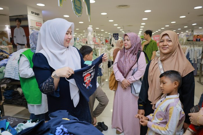 Bunda PAUD Aceh Besar Hj Rita Mayasari, membantu para anak yatim memilih baju lebaran, di pusat perbelanjaan di Kota Banda Aceh, Selasa (17/2/2026). FOTO/ MC ACEH BESAR
