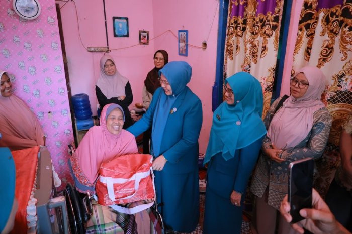 Ketua TP-PKK Kabupaten Aceh Besar, Hj. Rita Mayasari. Ia turun langsung menyerahkan bantuan kursi roda dan paket sembako kepada Nismawati (60), warga Gampong Meunasah Tunong, Kecamatan Seulimeum, Kamis (12/02/2026). FOTO/MC ACEH BESAR 