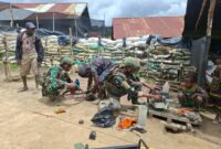 Prajurit TNI Satgas Yonif 408/Sbh membantu seorang warga memperbaiki mesin senso (chainsaw) yang menjadi alat utama untuk bekerja di Kampung Tumbupur, Distrik Kuyawage, Kabupaten Lanny Jaya, Senin (16/3/2026).