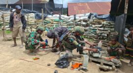 Prajurit TNI Satgas Yonif 408/Sbh membantu seorang warga memperbaiki mesin senso (chainsaw) yang menjadi alat utama untuk bekerja di Kampung Tumbupur, Distrik Kuyawage, Kabupaten Lanny Jaya, Senin (16/3/2026).