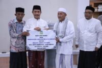 Wakil Bupati Aceh Besar Drs Syukri A Jalil menyerahkan bantuan semen dan ambal sajadah untuk Masjid Jamik Lamrabo, Gampong Deyah, Kecamatan Kuta Baro, Aceh Besar, Minggu (1/3/2026). 