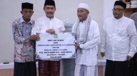 Wakil Bupati Aceh Besar Drs Syukri A Jalil menyerahkan bantuan semen dan ambal sajadah untuk Masjid Jamik Lamrabo, Gampong Deyah, Kecamatan Kuta Baro, Aceh Besar, Minggu (1/3/2026). 