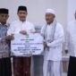 Wakil Bupati Aceh Besar Drs Syukri A Jalil menyerahkan bantuan semen dan ambal sajadah untuk Masjid Jamik Lamrabo, Gampong Deyah, Kecamatan Kuta Baro, Aceh Besar, Minggu (1/3/2026). 