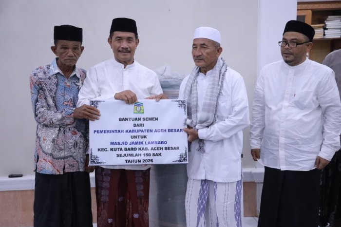 Wakil Bupati Aceh Besar Drs Syukri A Jalil menyerahkan bantuan semen dan ambal sajadah untuk Masjid Jamik Lamrabo, Gampong Deyah, Kecamatan Kuta Baro, Aceh Besar, Minggu (1/3/2026). 